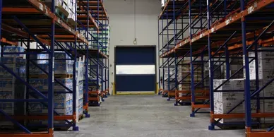 A warehouse with many shelves and a door.